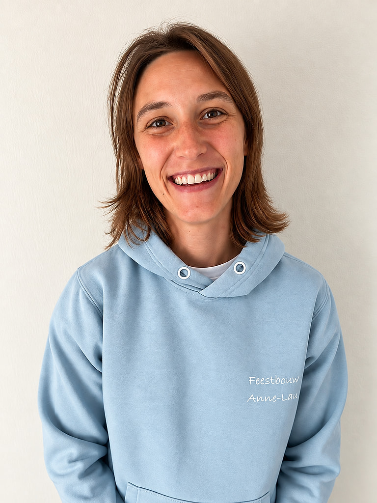 Anne-Laure van De Feestbouwers, lachend in een lichtblauwe hoodie