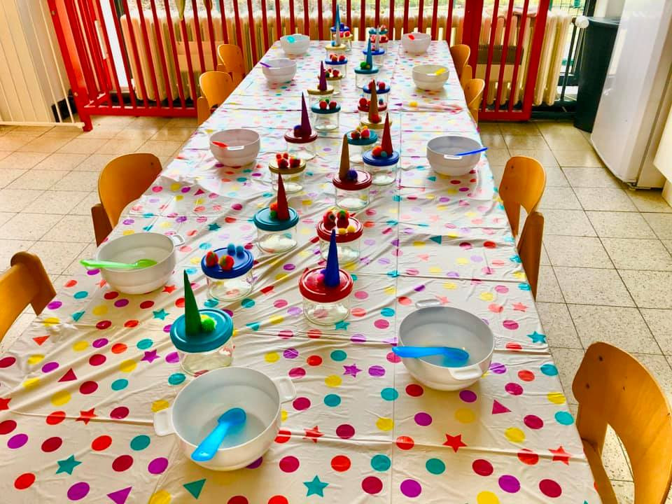 Een lange gedekte feesttafel met gestippeld tafelkleed en eenhoornhoorntjes bij elk bord.