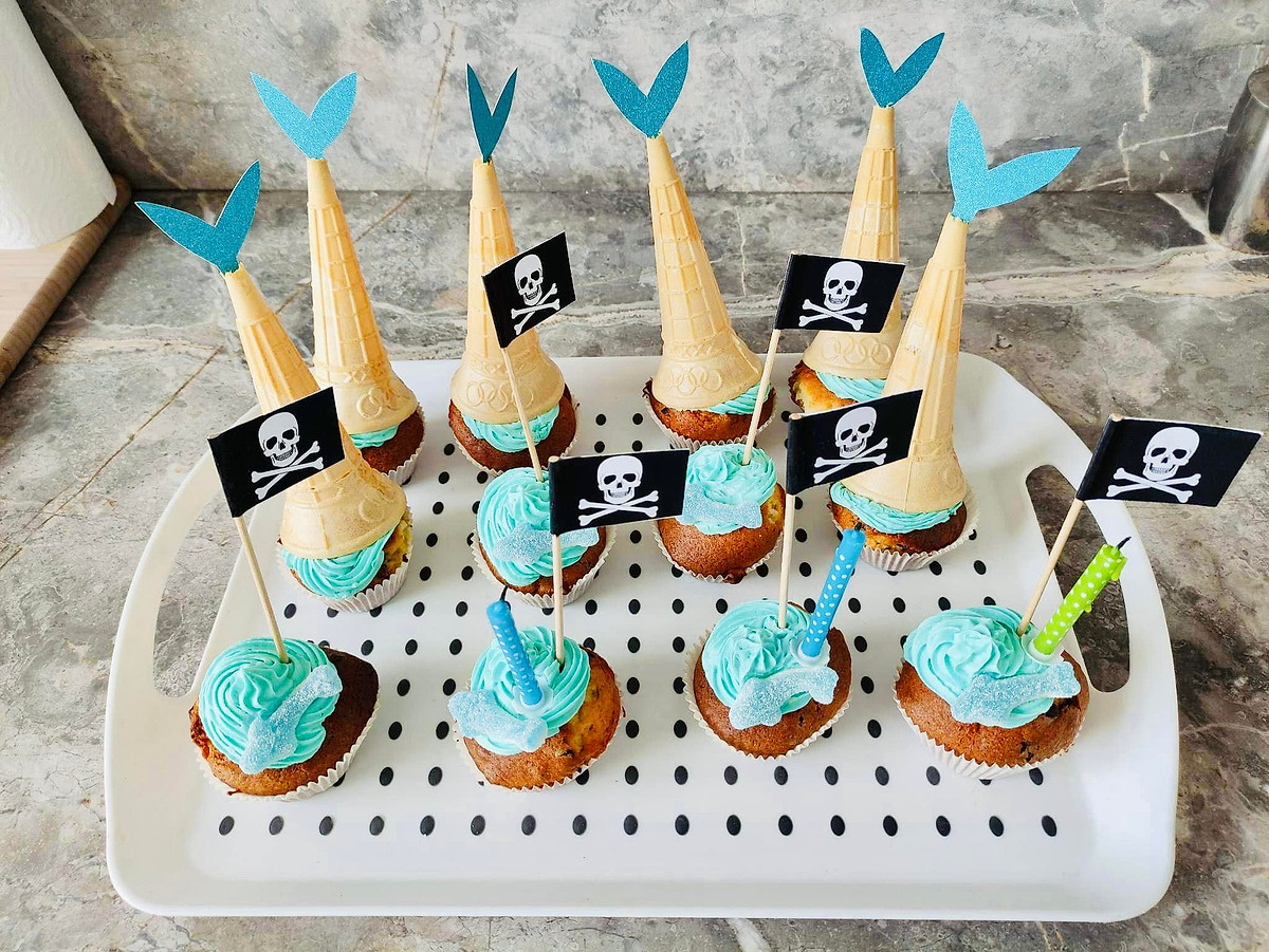 Cupcakes met blauwe crème, ijshoorntjes en piratenvlaggetjes.